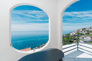 a room with a window with a view of the ocean at Albergo Dipinto BaccoFurore in Furore