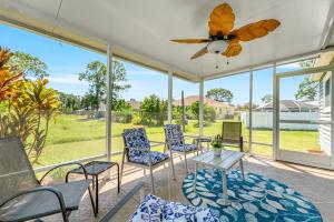 a screened porch with chairs and a ceiling fan at 3BR Coastal Escape Near Beaches, Golf, Shops in North Port