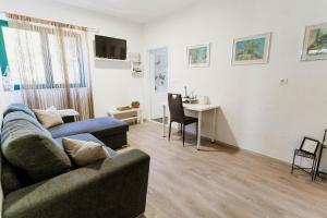 ein Wohnzimmer mit einer Couch und einem Tisch und einem Schreibtisch in der Unterkunft Villa Mia Filomena in Sevid