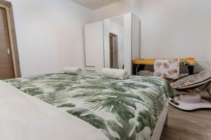 ein Schlafzimmer mit einem Bett mit einer grünen Blattdecke in der Unterkunft Villa Mia Filomena in Sevid