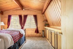 a bedroom with a bed in a wooden cabin at The Lions Den in Big Bear City