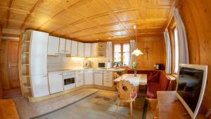a kitchen with white cabinets and a table in a room at Appart Alte Post in Partenen