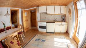 a small kitchen with white cabinets and a stove at Appart Alte Post in Partenen