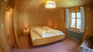 a bedroom with a bed in a wooden room at Appart Alte Post in Partenen