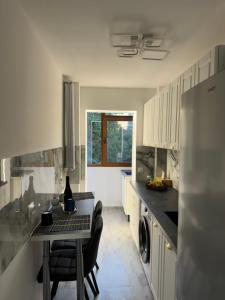 a kitchen with a table and a refrigerator at Studio Kiki by the Lujerului metro station in Bucharest