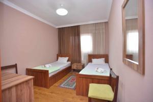 a room with two beds and a chair in it at Art House Hostel Aleksandr in Kutaisi