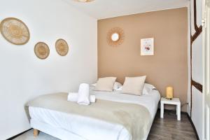 a bedroom with a white bed with towels on it at Au nid des remparts à Eguisheim in Eguisheim