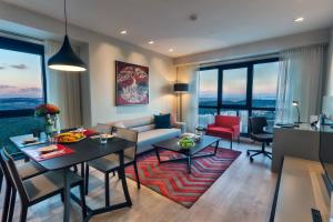 a living room with a couch and a table and chairs at Fraser Place Antasya Istanbul in Istanbul