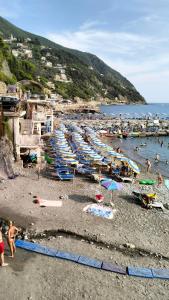 a group of people on a beach with boats at bb Margherita seaside, 20 minutes from the Cinque Terre by train in Moneglia