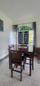 a wooden table and chairs in a room with a window at Palm Breeze Villa JM in Lucea