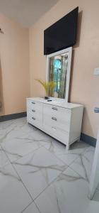 a white dresser with a television on top of it at Palm Breeze Villa JM in Lucea