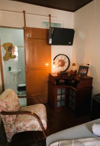 a room with a bed and a desk with a fan at Hospedagem Rancho Fundo in Diamantina