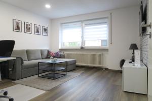 un salon avec un canapé et une table dans l'établissement Ferienwohnung Loh - 55Zoll TV - Schnelles Internet 500MBit, à Schwäbisch Hall