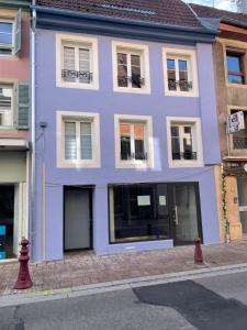 a purple building on the side of a street at Les nuitées du Rangen in Thann