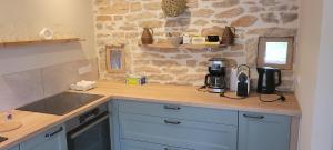 a kitchen with blue cabinets and a counter top at La Saugeraie in Étrigny