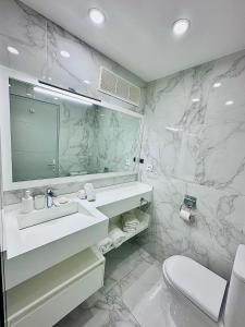 ein Badezimmer mit Waschbecken, Spiegel und Toilette in der Unterkunft Sea Breeze magnifique 2 chambres in Baie Nettle