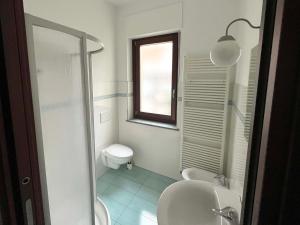 une salle de bain avec toilettes, lavabo et fenêtre dans l'établissement La Magnolia, à Alba