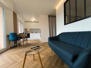 a living room with a blue couch and a table at Agréable Studio Chantilly avec balcon et parking securisé in Pau