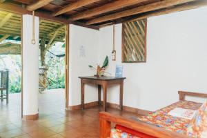 um quarto com uma mesa e um banco num quarto em El Zopilote em Balgue