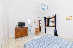 a bedroom with a bed and a tv and a dresser at Il Merlo Capri in Capri