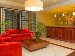 コスメルにあるHotel Casa Colonial Cozumelのリビングルーム(赤いソファ、コーヒーテーブル付)