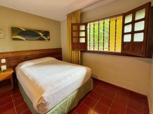 a small bedroom with a bed and a window at Hotel Casa Colonial Cozumel-Dog Friendly in Cozumel +12 photos
