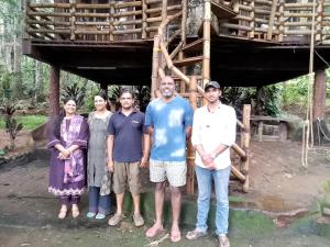 a group of people standing in front of a tree house at Jungle Tree House Munnar in Munnar