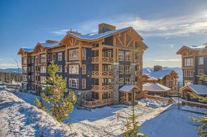 a large building with snow in front of it at Stonegate Resort Unit C304 in Big White