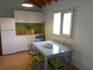 a kitchen with a table and chairs and a refrigerator at casa vacanza suite Etna-Mare in Zafferana Etnea