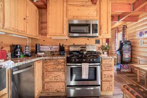 a kitchen with a stove and a microwave at The Lions Den in Big Bear City +19 photos