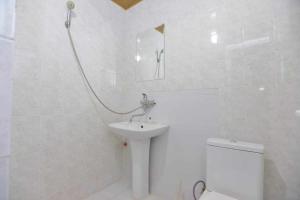 a white bathroom with a sink and a toilet at Art House Hostel Aleksandr in Kutaisi