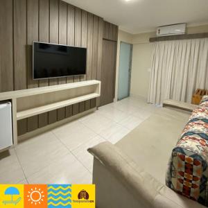 a living room with a flat screen tv on a wall at Piazza diRoma com acesso ao Acqua Park e Splash - Temporada CN Adriele in Caldas Novas
