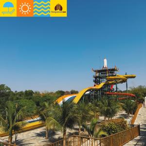 a roller coaster at a theme park with palm trees at Piazza diRoma com acesso ao Acqua Park e Splash - Temporada CN Adriele in Caldas Novas
