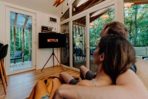 Televízia a/alebo spoločenská miestnosť v ubytovaní Maroska Forest Cabin & Wellness