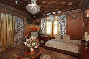 a bedroom with a bed and a table with flowers at Swift houseboats in Srinagar