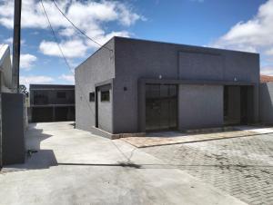 a gray building with glass doors on a street at Sobrado para hóspedes in Guarapuava