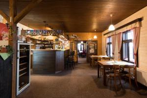 un ristorante con tavoli e sedie e un bar di Hotel Vyhlídka a Jilemnice