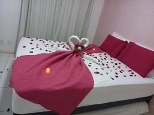 a bed with a purple blanket on top of it at Flat Porto de Galinhas in Porto De Galinhas +54 photos