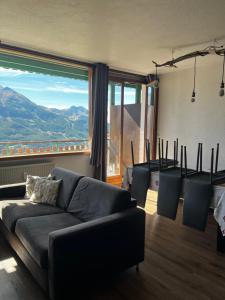 un salon avec un canapé et une grande fenêtre dans l'établissement Orcières Merlette, à Orcières