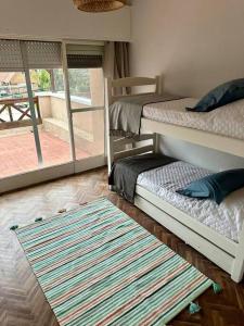 ein Zimmer mit zwei Etagenbetten und einem Teppich in der Unterkunft Casa Figari, Carrasco, divina zona cerca de la rambla in Montevideo