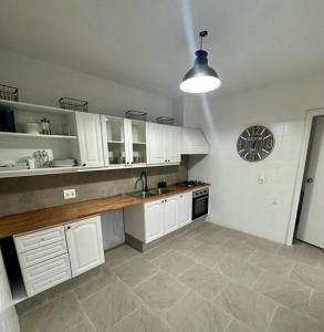 eine Küche mit weißen Schränken und einer Uhr an der Wand in der Unterkunft Casa Figari, Carrasco, divina zona cerca de la rambla in Montevideo