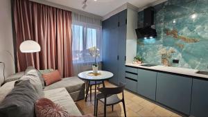 Una sala de estar con un sofá y una mesa y una cocina. en Blue Apartment, en Mukácheve