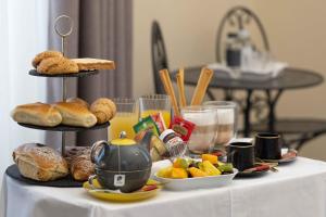 a table with bread and pastries and a tea pot at Domus Deorum Deluxe in Naples