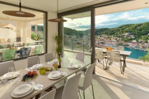 una sala da pranzo con tavolo e sedie e un balcone di The Glass House a Pučišća