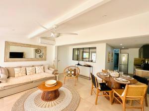 a living room with a couch and a table at Shell Beach Splendide 2 chambres sur la plage in Baie Nettle