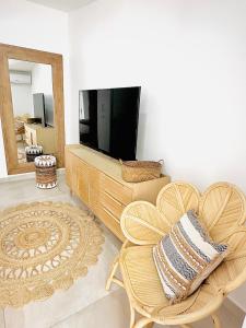 a living room with a television and a chair at Shell Beach Splendide 2 chambres sur la plage in Baie Nettle +35 photos