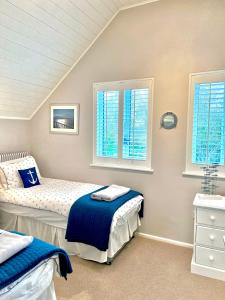 a bedroom with two beds and two windows at Herons Hideout in South Cerney +19 photos