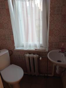 a bathroom with a toilet and a sink and a window at Dzīvoklis Vecliepājā in Liepāja +2 photos