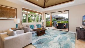 a living room with a couch and a table at SWEET ESCAPE Stylish KaMilo 3BR Home with Private Beach Club Bikes in Waikoloa