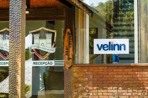 a sign in the window of a building with a surfboard at VELINN Pousada Torre Branca in Monte Verde